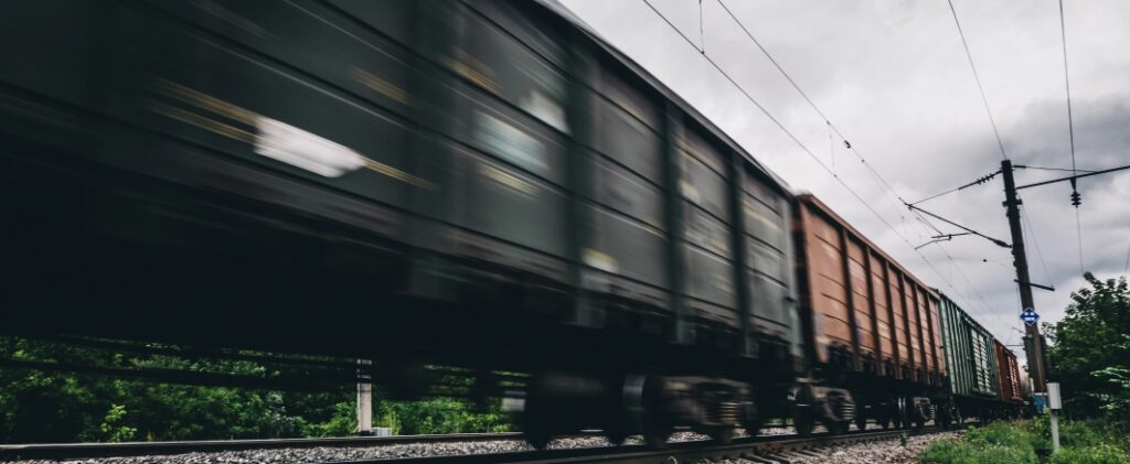 Motion blur image of a freight train in motion on railway tracks, symbolizing speed and efficiency in transportation
